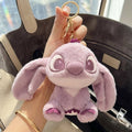 Plush keychain shaped like a cartoon character held by a hand in front of a bag.