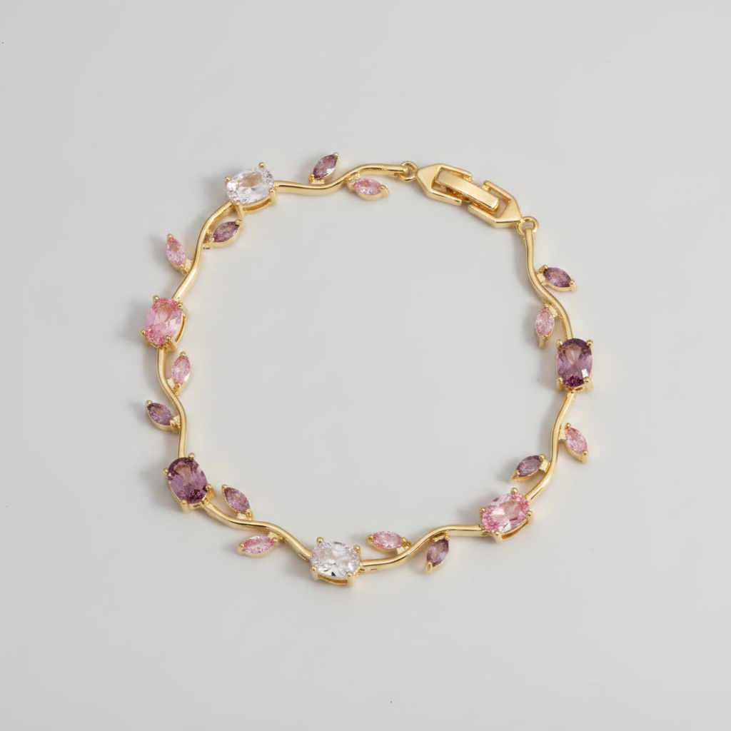 Gold bracelet with pink and clear gemstones on a beige background