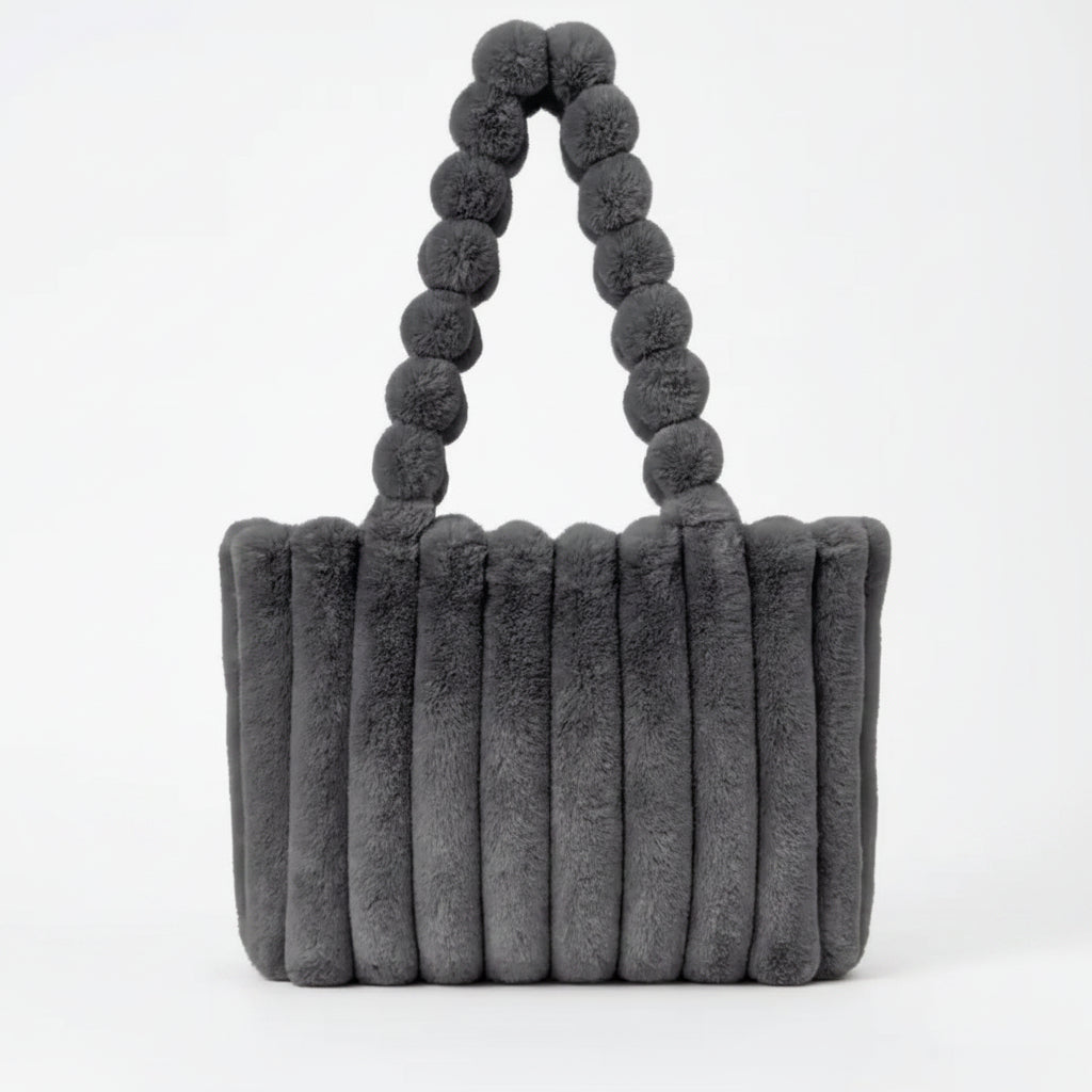 Gray textured handbag with pom-pom handles on a white background