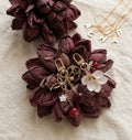 Necklace with floral and berry charms on a textured surface